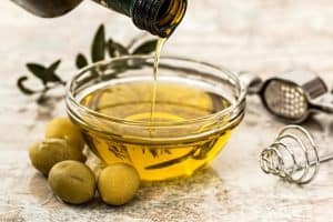 aceite de oliva echandose en un recipiente de cristal