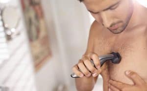 hombre usando afeitadora corporal en el pecho