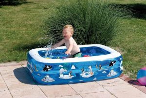 niño pequeño feliz en una piscina hinchable