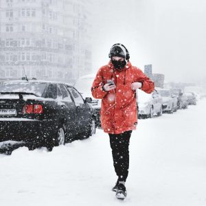 hombre corriendo con auriculares en la nieve