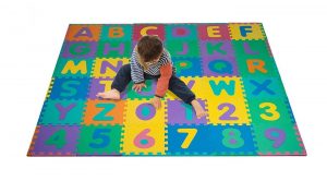 niño en una alfombra infantil de puzzle